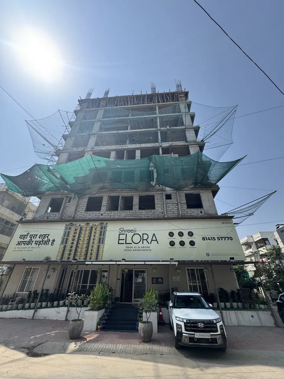 Shreeji Elora tower under construction, with the project hoarding at the entrance