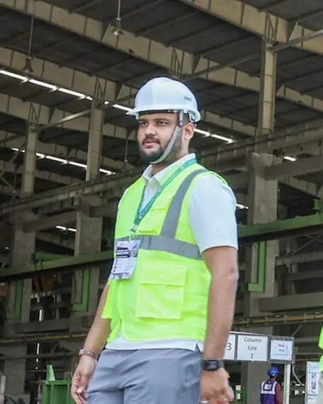 Portrait of Yagnesh Soni in a hard hat and safety vest at a precast production hall